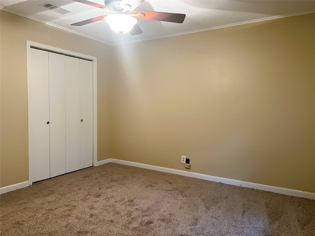 unfurnished bedroom with carpet floors, ornamental molding, a closet, and ceiling fan