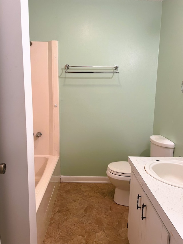 bathroom with vanity, a bath, and toilet