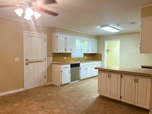 kitchen with tasteful backsplash, crown molding, stainless steel dishwasher, and white cabinets