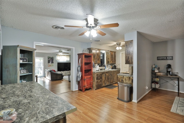 kitchen featuring light hardwood / wood-style floors, sink, and a textured ceiling