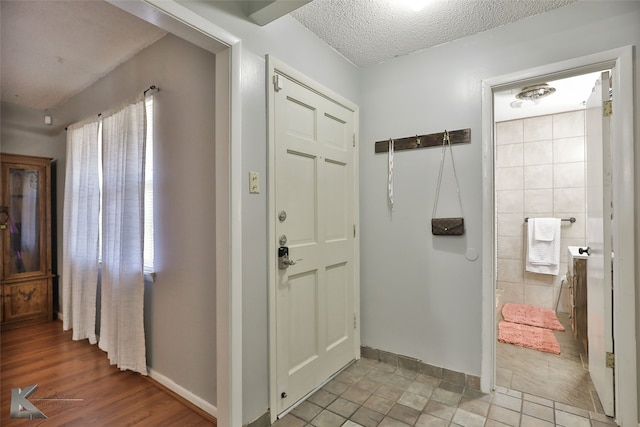 entryway with a textured ceiling and light wood-type flooring