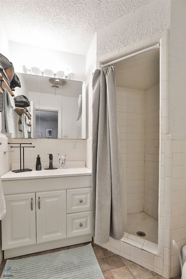 bathroom featuring vanity, tasteful backsplash, walk in shower, and tile walls