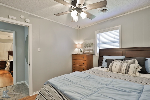 bedroom with ceiling fan, a textured ceiling, and ornamental molding