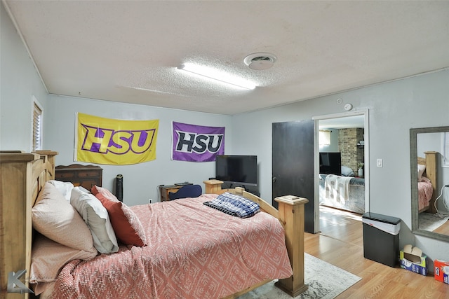 bedroom featuring a textured ceiling and light hardwood / wood-style floors