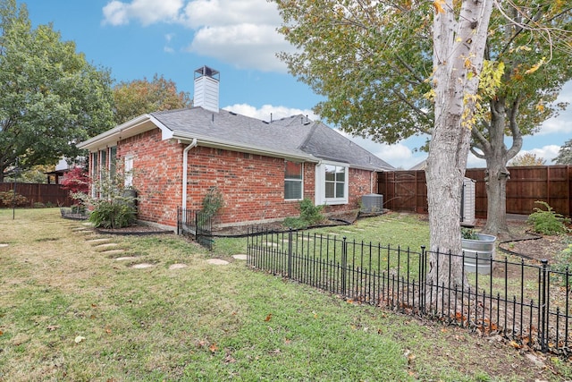 view of property exterior featuring a chimney, brick siding, a yard, and a fenced backyard