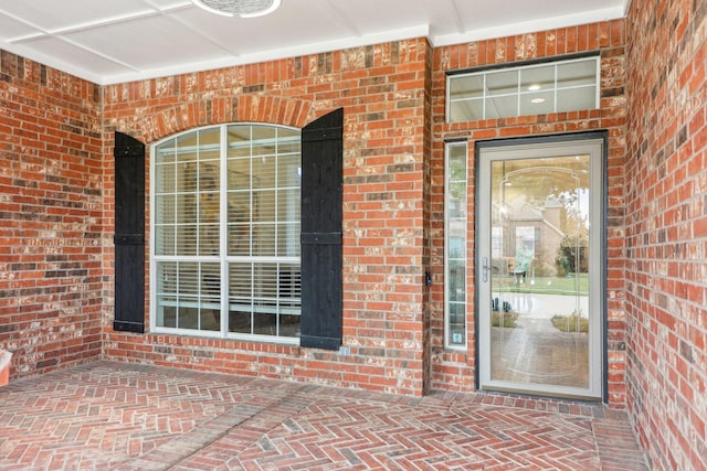 entrance to property featuring brick siding