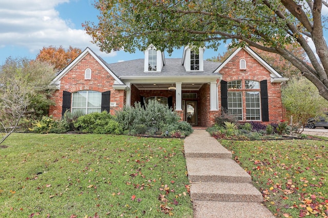 view of front of home with brick siding and a front lawn