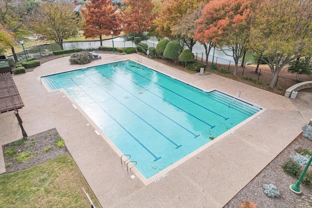 community pool with a patio and fence