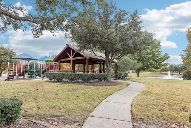 view of home's community featuring playground community and a lawn