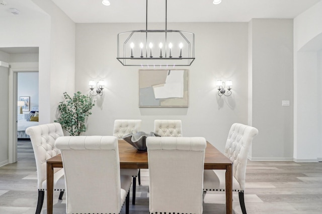 dining space with recessed lighting, baseboards, an inviting chandelier, and wood finished floors