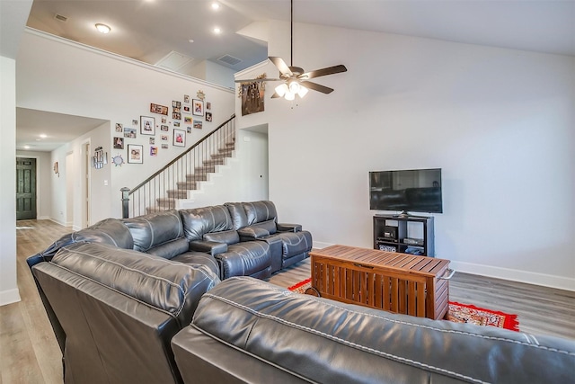 living room featuring ceiling fan, high vaulted ceiling, and light hardwood / wood-style flooring