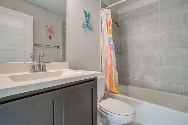 full bathroom featuring vanity, shower / bath combo, and toilet