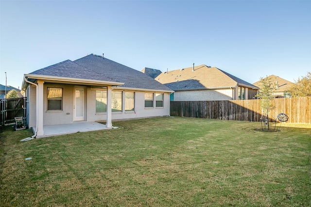 rear view of property featuring a yard and a patio area