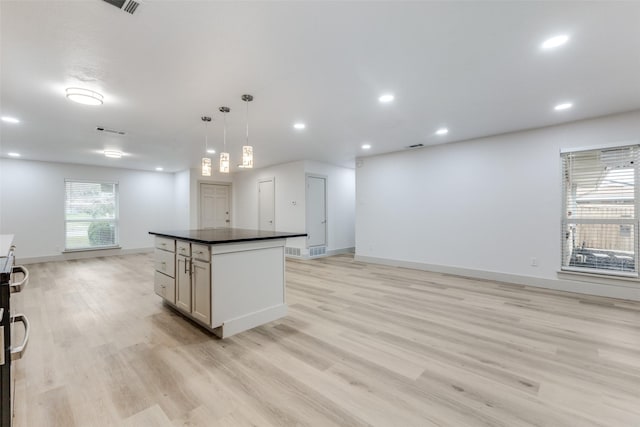 kitchen with hanging light fixtures, light hardwood / wood-style floors, a kitchen island, and white cabinets