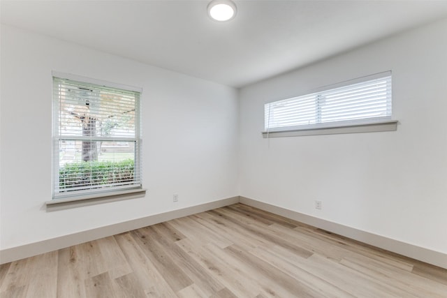 spare room with a wealth of natural light and light hardwood / wood-style floors