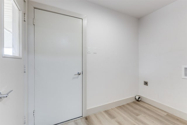 clothes washing area with electric dryer hookup and light wood-type flooring