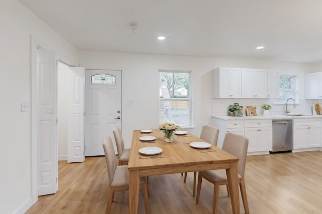 dining area with light hardwood / wood-style floors, a healthy amount of sunlight, and sink