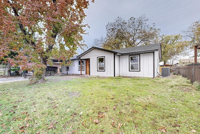 view of front of property with central air condition unit and a front lawn