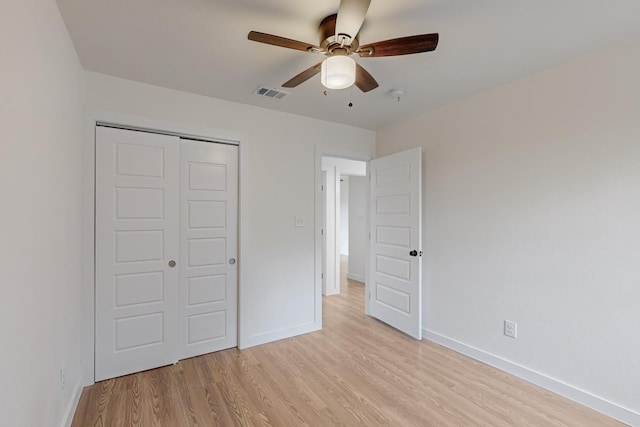 unfurnished bedroom featuring a closet, light hardwood / wood-style floors, and ceiling fan