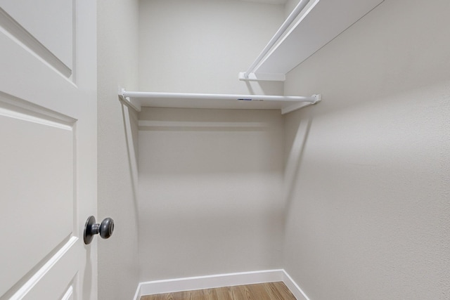 walk in closet with light hardwood / wood-style floors