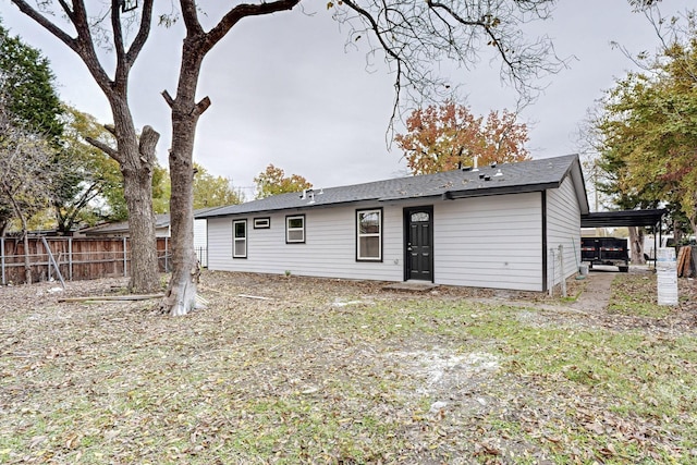 back of house featuring a carport