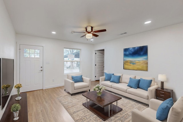 living room with ceiling fan and light hardwood / wood-style flooring