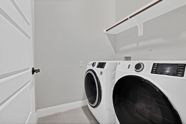 clothes washing area featuring light tile patterned flooring and washing machine and dryer