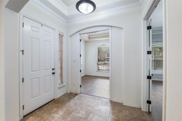 unfurnished bedroom featuring crown molding, ensuite bath, hardwood / wood-style flooring, ceiling fan, and a tray ceiling