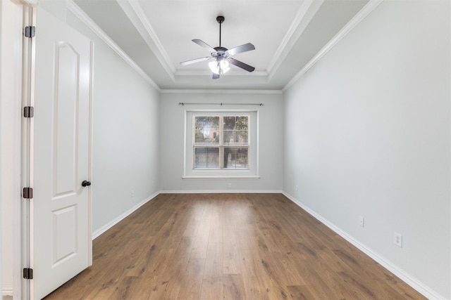 unfurnished room featuring hardwood / wood-style flooring, a tray ceiling, ornamental molding, and ceiling fan