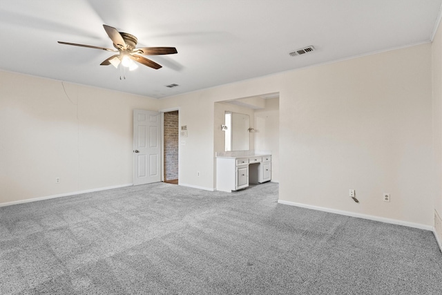 empty room with ceiling fan, carpet floors, and crown molding