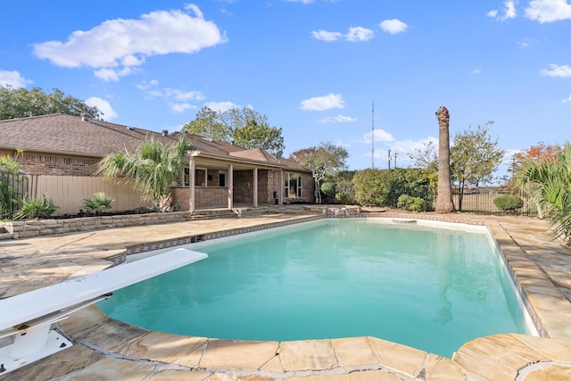 view of swimming pool featuring a diving board