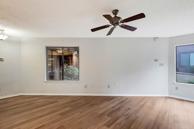 empty room featuring ceiling fan, hardwood / wood-style floors, and a textured ceiling