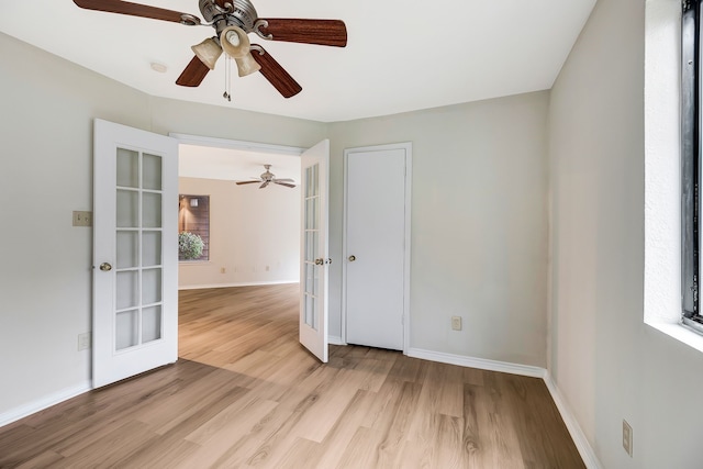 empty room with light wood-type flooring and french doors