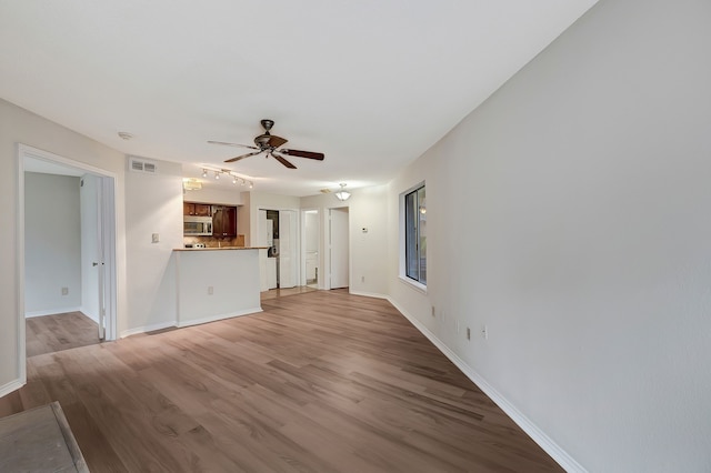 unfurnished living room with ceiling fan and light hardwood / wood-style flooring