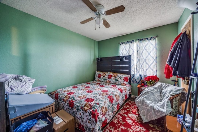 bedroom with ceiling fan and a textured ceiling