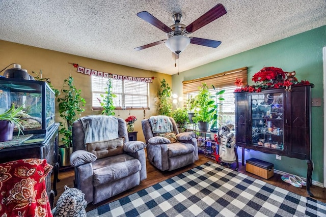 living room with a textured ceiling, dark hardwood / wood-style flooring, and ceiling fan