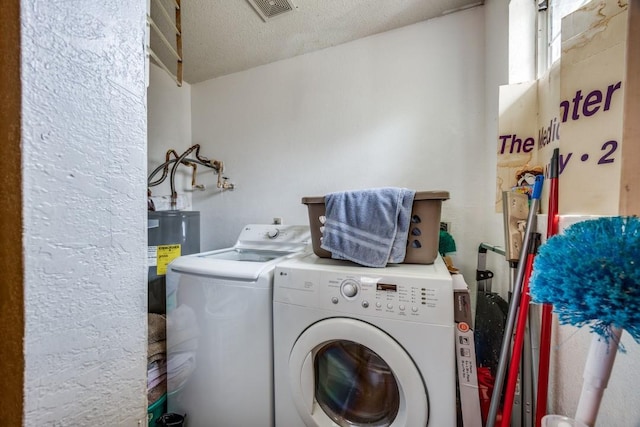 washroom featuring washing machine and dryer and a textured ceiling