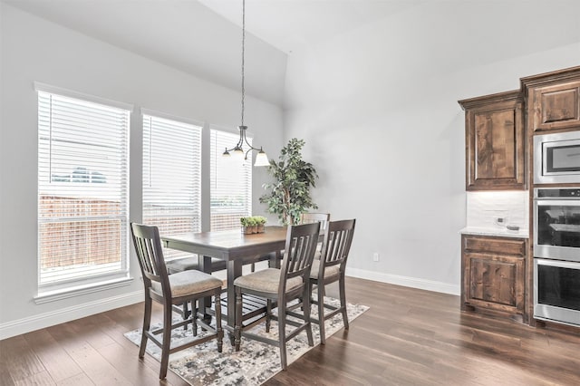 dining space with dark hardwood / wood-style flooring and vaulted ceiling