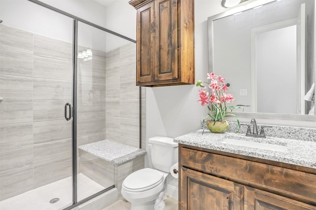 bathroom with vanity, toilet, and a shower with shower door