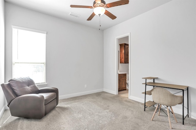 living area with light colored carpet and ceiling fan