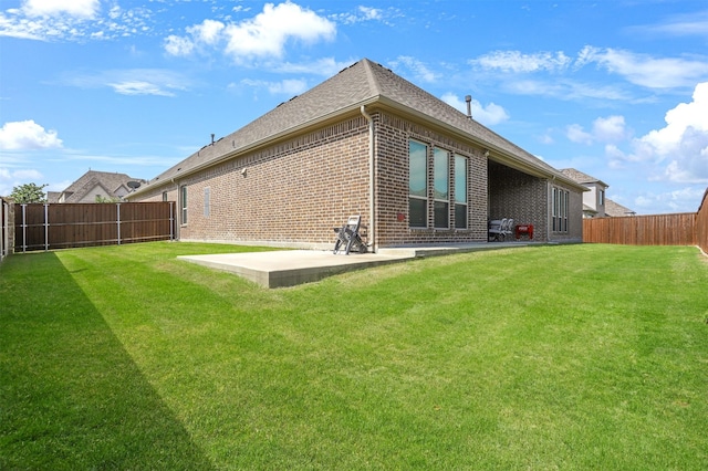 back of property with a yard and a patio