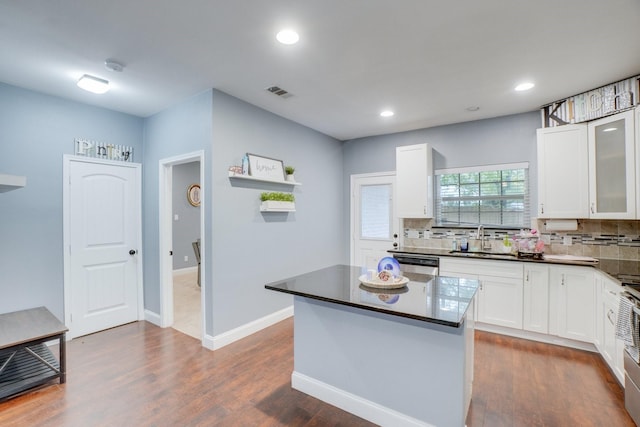 kitchen featuring dark hardwood / wood-style flooring, sink, dishwasher, white cabinets, and a center island