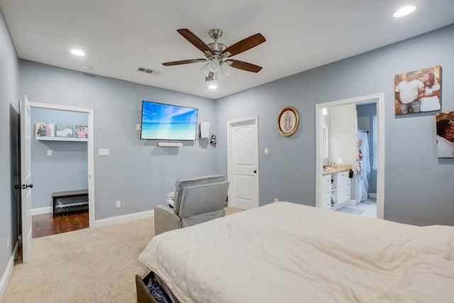 carpeted bedroom with ceiling fan and ensuite bathroom