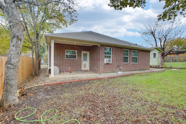 rear view of property with a yard and a patio area