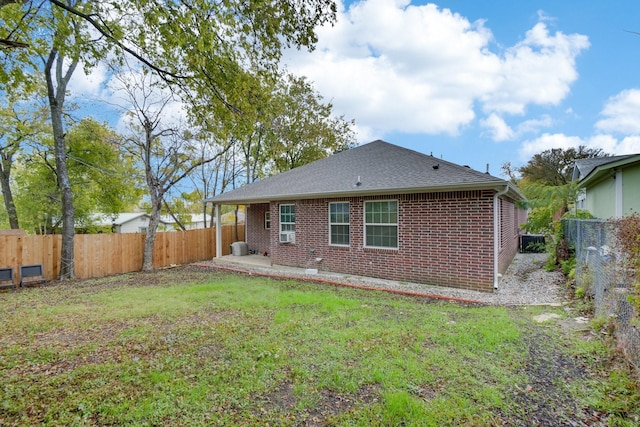 back of house featuring a lawn and a patio