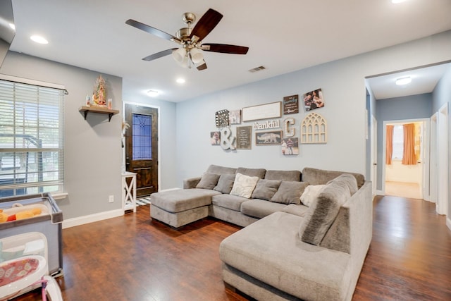 living room with ceiling fan and dark wood-type flooring