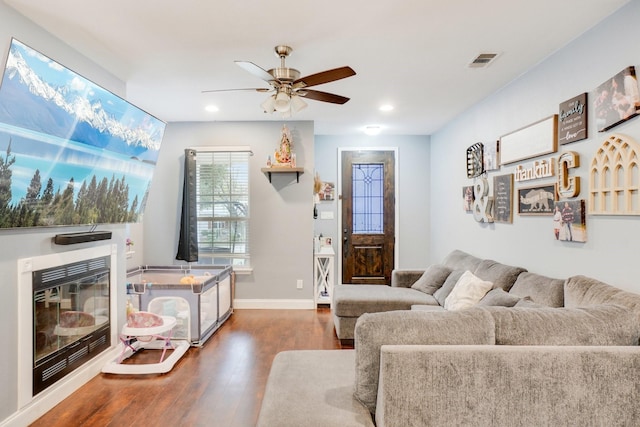 living room featuring ceiling fan and dark hardwood / wood-style flooring