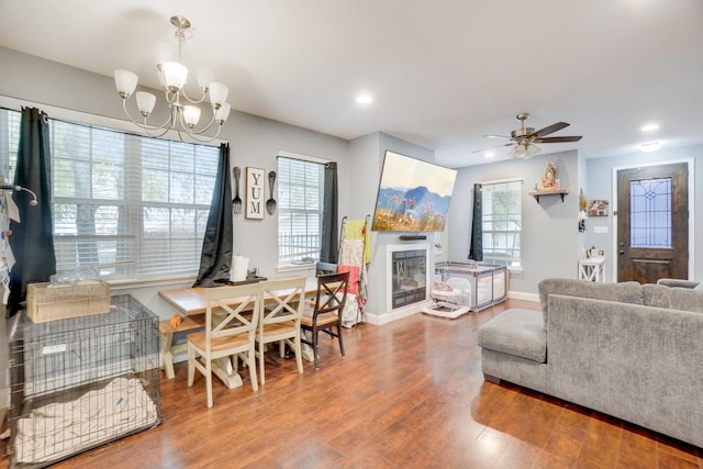 living room featuring ceiling fan with notable chandelier and hardwood / wood-style floors