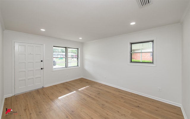 entryway with plenty of natural light, crown molding, and light hardwood / wood-style flooring