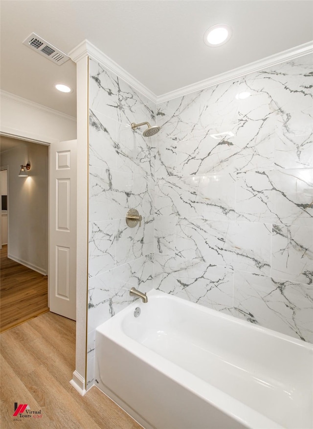 bathroom featuring tiled shower / bath combo, wood-type flooring, and crown molding